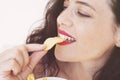 Young woman eating potato chips out of a bowl against Royalty Free Stock Photo