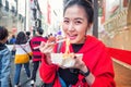 Young woman eating Roasted lobster with cheese at Myeong-dong street food in Seoul, South Korea