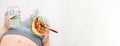 Young woman is eating a salad and using a fitness app on her smartphone after a workout. Royalty Free Stock Photo