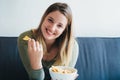 Young woman eating snacks on the couch Royalty Free Stock Photo