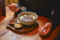 Young woman eating soup served in a white bowl. Eating out. Restaurant concept. Woman` s hand holding spoon. Royalty Free Stock Photo