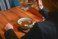 Young woman eating soup served in a white bowl. Eating out. Restaurant concept. Woman` s hand holding spoon. Royalty Free Stock Photo