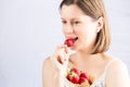 Young woman eating strawberry. Healthy snack for vegetarians.