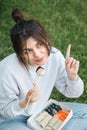 A young woman eating sushi in the park, picnic in nature. Royalty Free Stock Photo