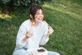 A young woman eating sushi in the park, picnic in nature. Royalty Free Stock Photo