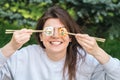 A young woman eating sushi in the park, picnic in nature. Royalty Free Stock Photo