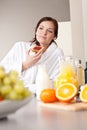 Young woman eating toast for breakfast in kitchen Royalty Free Stock Photo