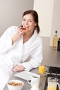 Young woman eating toast for breakfast in kitchen Royalty Free Stock Photo