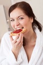 Young woman eating toast for breakfast in kitchen Royalty Free Stock Photo