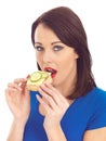 Young Woman Eating Toasted Crumpet with Cheese and Cucumber Royalty Free Stock Photo