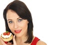 Young Woman Eating Toasted Crumpet with Cream Cheese and Tomato Royalty Free Stock Photo