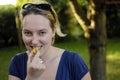 Young woman eating yellow plum