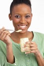 Young Woman Eating Yoghurt In Studio Royalty Free Stock Photo