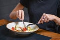 Young woman eats caesar salad of traditional recipe in restaurant or diner. Eating out concept Royalty Free Stock Photo