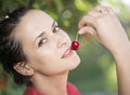 Young woman eats cherry outdoor Royalty Free Stock Photo