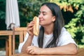 A young woman eats a hot dog on a cafe terrace. Royalty Free Stock Photo