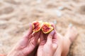 A young woman eats a ripe fig on the beach. Vacation and travel concept. Copy cpace. Selective focus Royalty Free Stock Photo