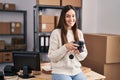 Young woman ecommerce business worker holding professional camera at office Royalty Free Stock Photo