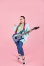 Young woman with electric guitar pretending like a rockstar isolated on color background Royalty Free Stock Photo