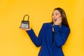 Young woman in elegant blue jacket is holding small purse and laughing Royalty Free Stock Photo