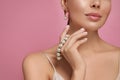 Young woman with elegant pearl jewelry on pink background, closeup. Space for text Royalty Free Stock Photo