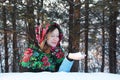 The young woman in an elegant woolen scarf looking at snow