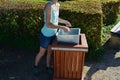 Young woman emptying a trash can in the park. it is her job or a summer job in a municipal gardening company serving citizens. hol Royalty Free Stock Photo