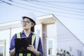 Young woman engineer or architechure hold clipboard and looking at construction site or work place and checking checklist. Concept Royalty Free Stock Photo