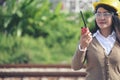 Young woman engineer or construction worker wearing safety hat helmet and holding blueprint with refinery plant background Royalty Free Stock Photo