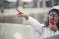 Young woman engineer or construction worker wearing safety hat helmet and holding portable radio with refinery plant background Royalty Free Stock Photo