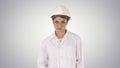 Young woman engineer in hard hat walking on gradient background. Royalty Free Stock Photo