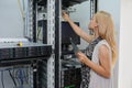 Young woman engineer It with tablet between the server racks