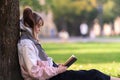 Young woman engrossed in reading a book outdoors