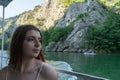 Young woman enjoying a journey in a ship in a lake crossing a river. Red hair White beautiful girl looking to the nature in Matka Royalty Free Stock Photo