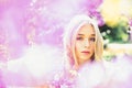 Young woman enjoy flowers in garden, defocused, close up. Girl on dreamy face, tender blonde near violet flowers of Royalty Free Stock Photo