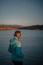 Young woman is enjoying beautiful view of sunset over norwegian fjord Royalty Free Stock Photo