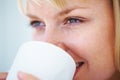 Young woman enjoying a cup of coffee. Closeup of young Caucasian woman drinking coffee and looking away.