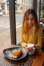 Young woman enjoying a cup of coffee and a slice of delicious ca