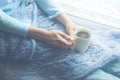 Young Woman Enjoying her morning coffee or tea, Looking Out the Window. Beautiful romantic unrecognizable girl drinking hot Royalty Free Stock Photo