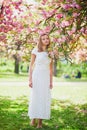 Young woman enjoying her walk in park during cherry blossom season on a nice spring day Royalty Free Stock Photo