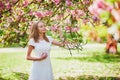 Young woman enjoying her walk in park during cherry blossom season on a nice spring day Royalty Free Stock Photo