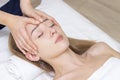 Young woman enjoying massage in spa salon. Face massage. Closeup of young woman getting spa massage treatment at beauty spa salon. Royalty Free Stock Photo