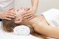 Young woman enjoying massage in spa salon. Face massage. Closeup of young woman getting spa massage treatment at beauty spa salon. Royalty Free Stock Photo