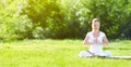young woman enjoying meditation and yoga on green grass in summer on nature Royalty Free Stock Photo