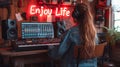 Young woman enjoying music with headphones in a cozy bohemian room illuminated by a neon sign saying Enjoy Life, promoting