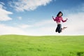 Young woman enjoying the new year jumping on field