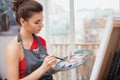 Young woman enjoying painting at her art studio