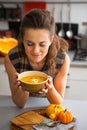 Young woman enjoying pumpkin soup in kitchen Royalty Free Stock Photo