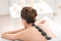 Young woman enjoying stone massage in spa salon Royalty Free Stock Photo