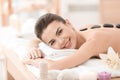 Young woman enjoying stone massage in spa salon Royalty Free Stock Photo